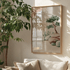 A sunlit room with a lush plant beside a Zen garden-themed painting from the Japandi Wall Art Set. The artwork depicts rocks and a small tree, with a cozy couch and cushions completing the ambiance.
