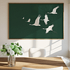 A serene dining room featuring a large Japandi Wall Art piece of white cranes flying on a dark green canvas. A vase of white and green flowers sits on a wooden table, enhancing the tranquil atmosphere.