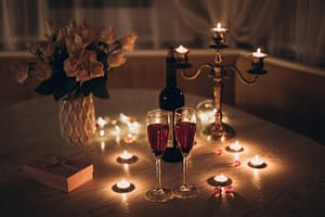 valentine day table decor candlelight-date-glasses-with-wine-candles-bouquet-rose-gift-box-table-romantic-candlelight-dinner-home-night