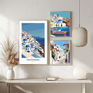 A trio of framed Santorini posters displayed in a minimalist, bright space. The posters, showcasing the island's picturesque landscapes and architecture, are paired with simple decor, including dried flowers and modern lighting.