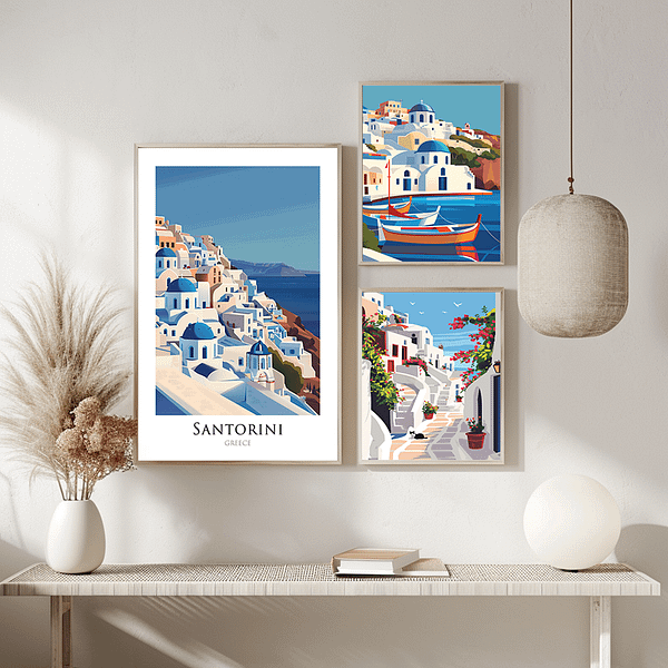 A trio of framed Santorini posters displayed in a minimalist, bright space. The posters, showcasing the island's picturesque landscapes and architecture, are paired with simple decor, including dried flowers and modern lighting.