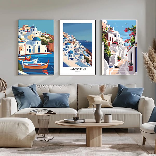 A trio of framed Santorini posters displayed in a minimalist, bright space. The posters, showcasing the island's picturesque landscapes and architecture, are paired with simple decor, including dried flowers and modern lighting.