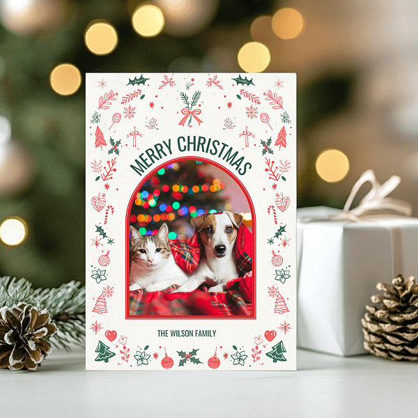 This customizable Christmas Card features the front page on a table surrounded by a white gift, pine branches, and pinecones for a festive holiday presentation.